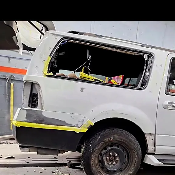 Costado de una SUV con daño estructural en el taller de J&B