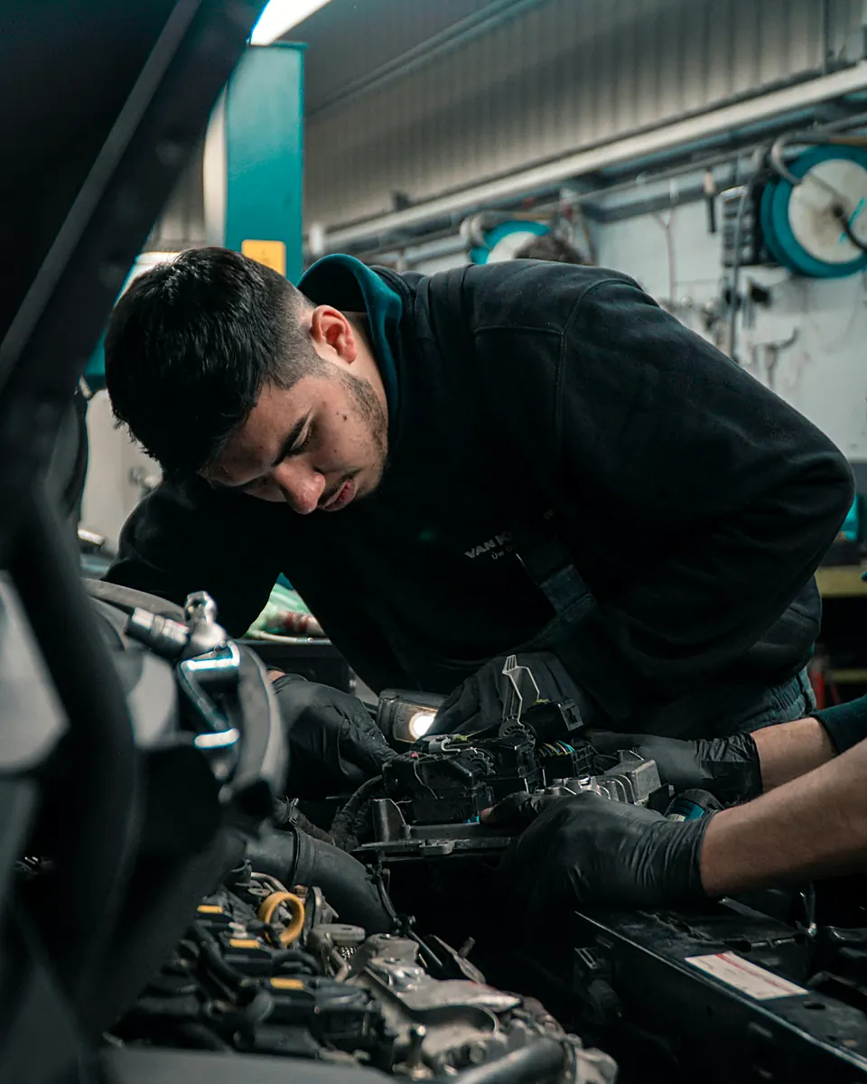 Mecánico trabajando en el motor de un carro