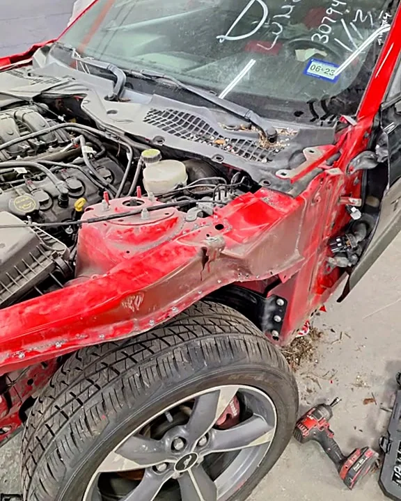 Ford Mustang rojo con el frente destrozado al llegar a J&B